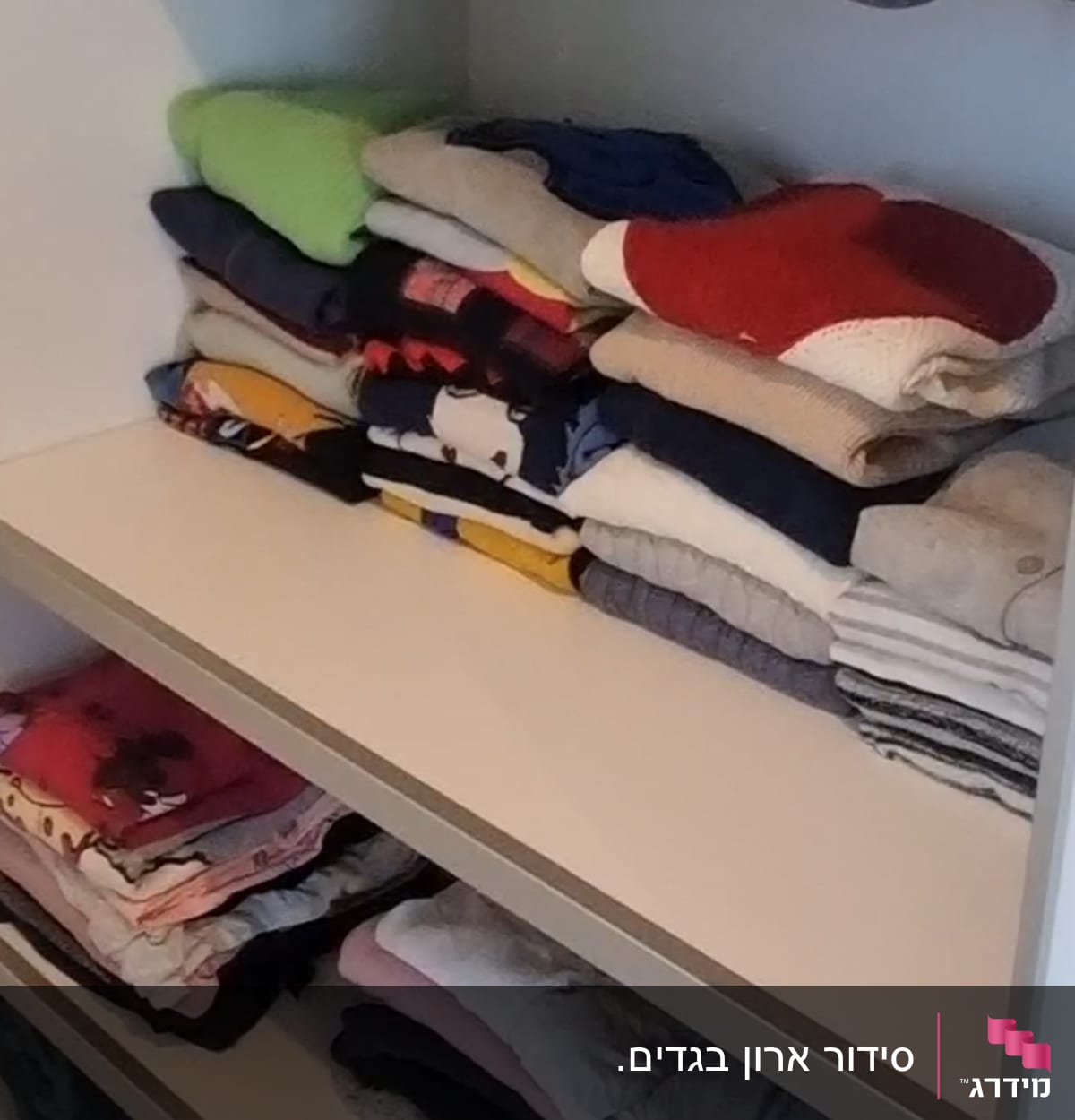 בגדים מקופלים על מדפים בארון עם תאים תלויים
